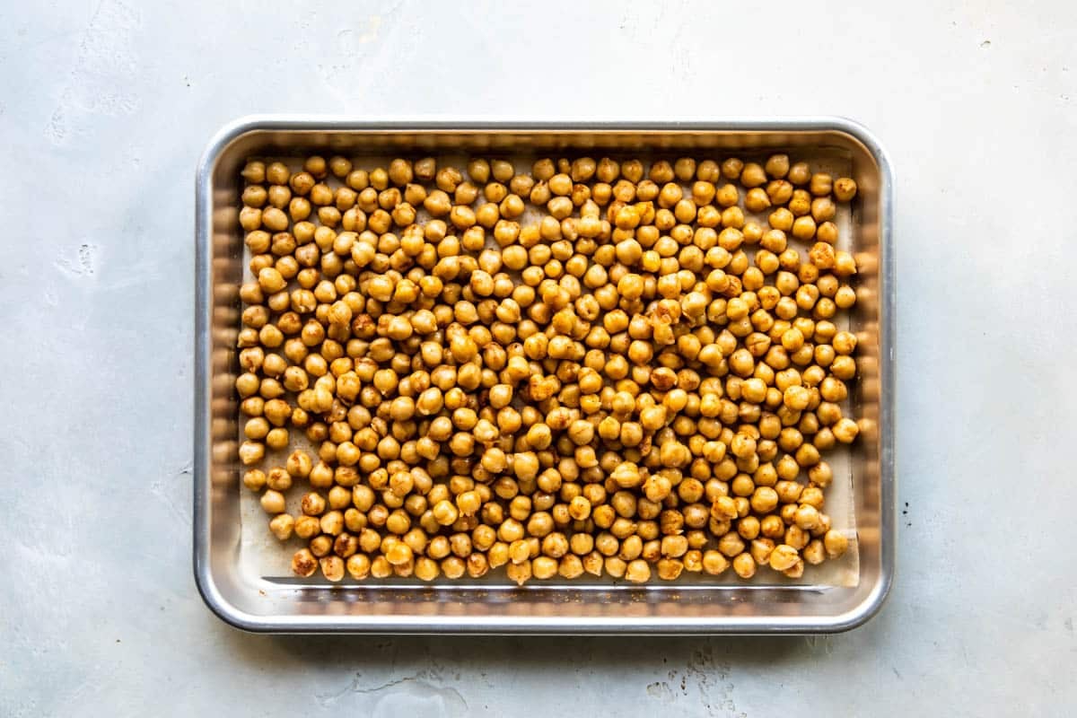 A baking tray full of canned chickpeas before roasting.