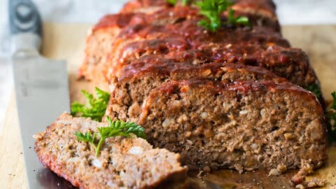 Meatloaf slices on a wooden cutting board.