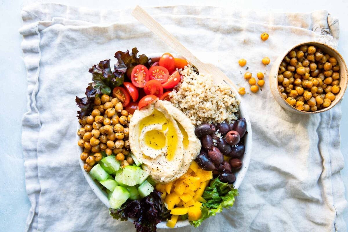 A Mediterranean Buddha bowl next to a small bowl of roasted chickpeas.