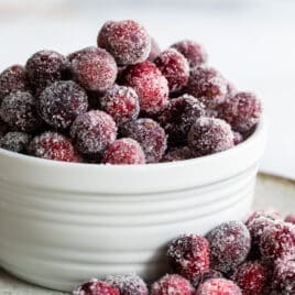Sugared cranberries in a small white bowl.