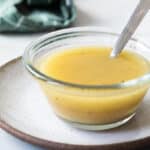 Apple cider vinaigrette in a clear bowl with a spoon.