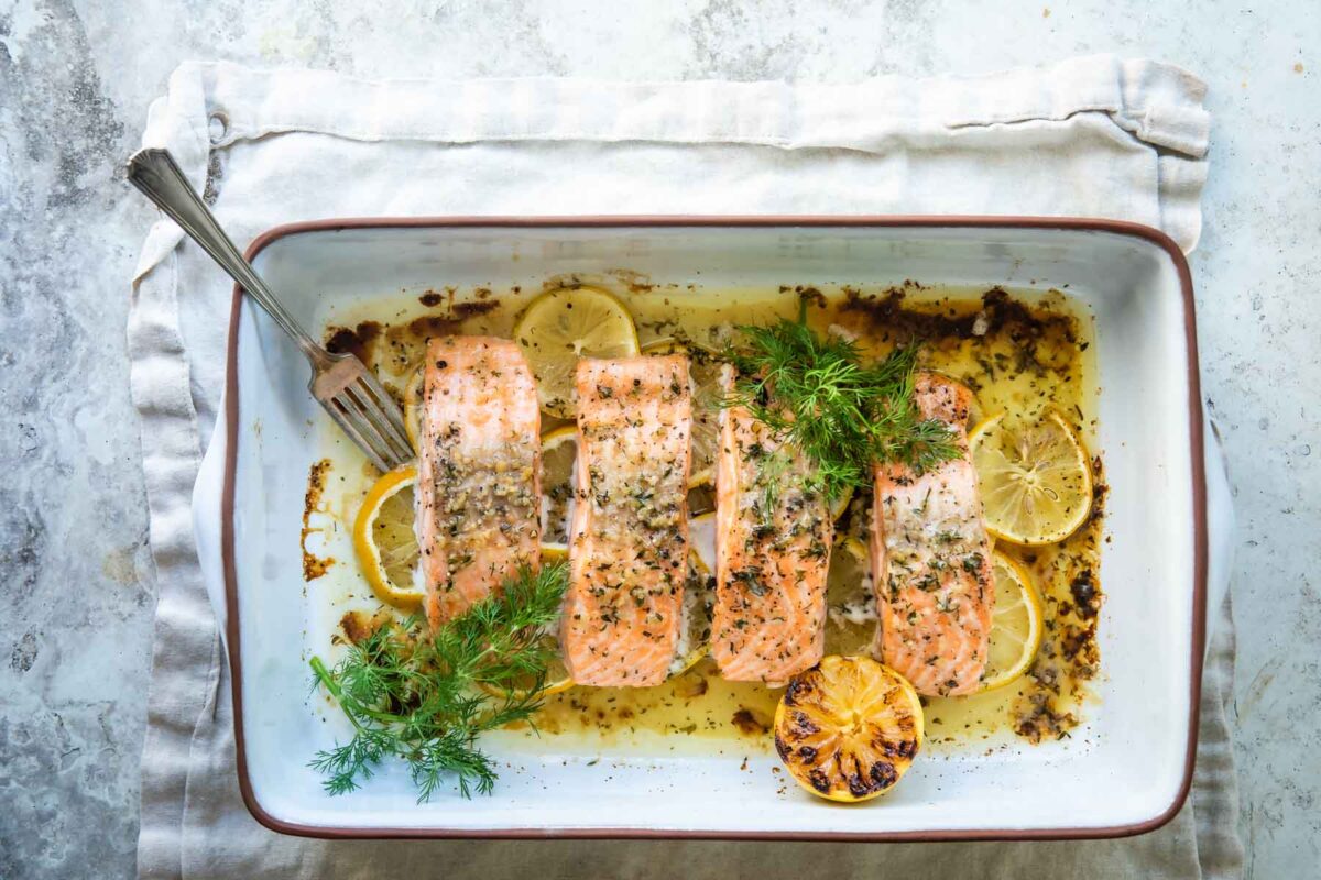 Salmon filets in a white baking dish after being baked.