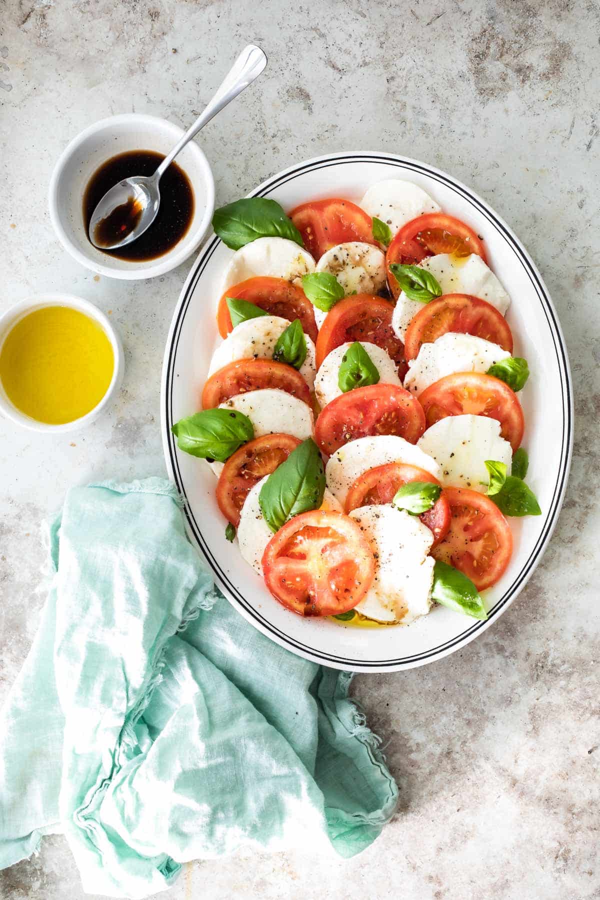 Caprese salad on a white oval plate.