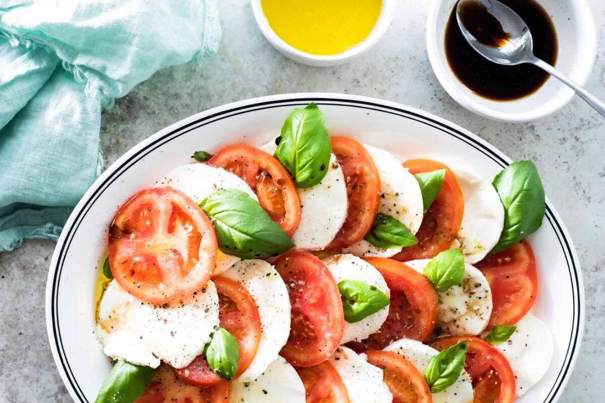 Caprese salad on a white oval plate.