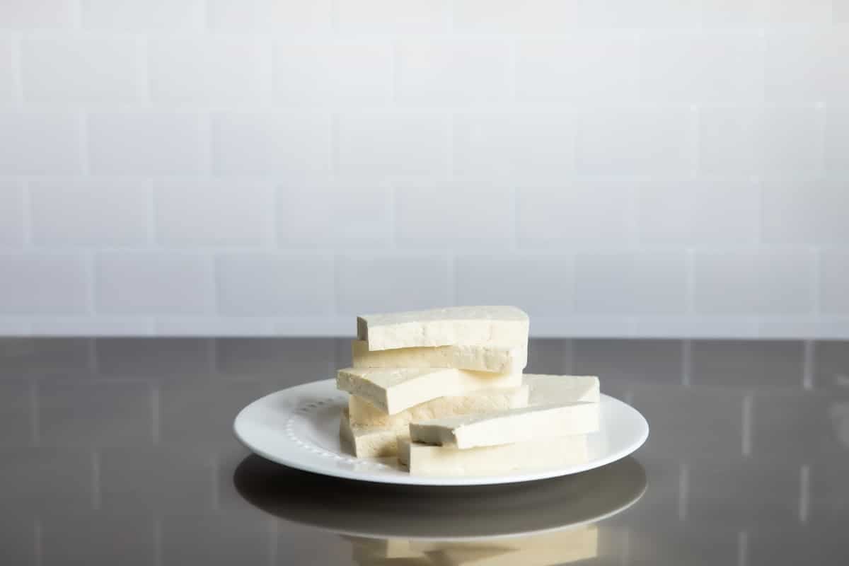 Slices of tofu on a white plate.