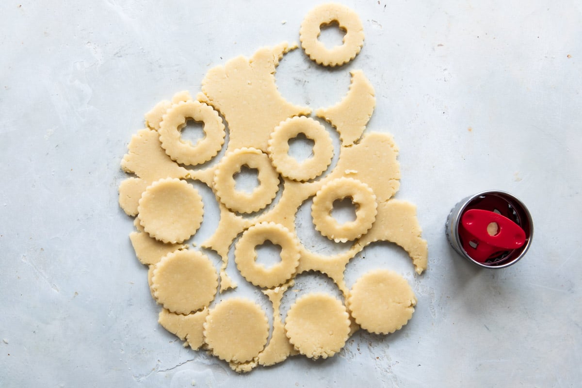 Cookie dough being cut into Linzer shapes.