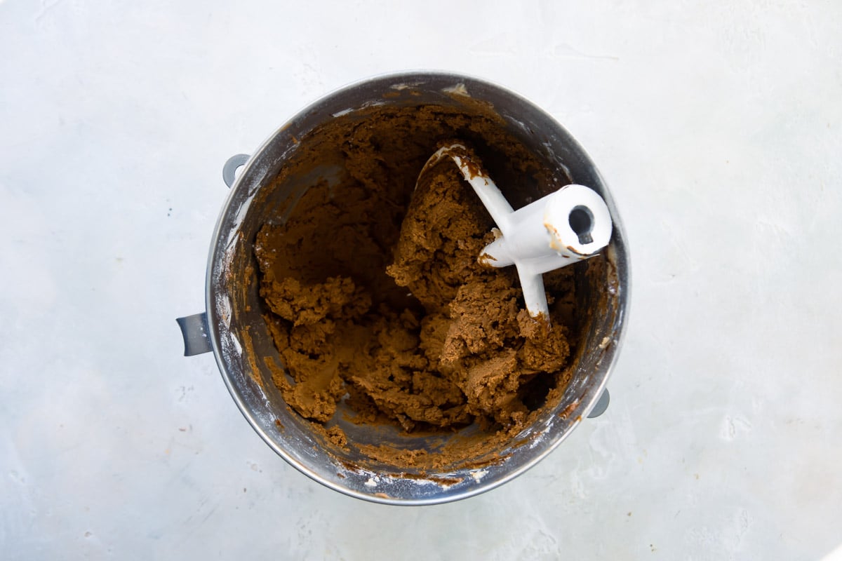 Molasses cookie dough in a silver mixing bowl.