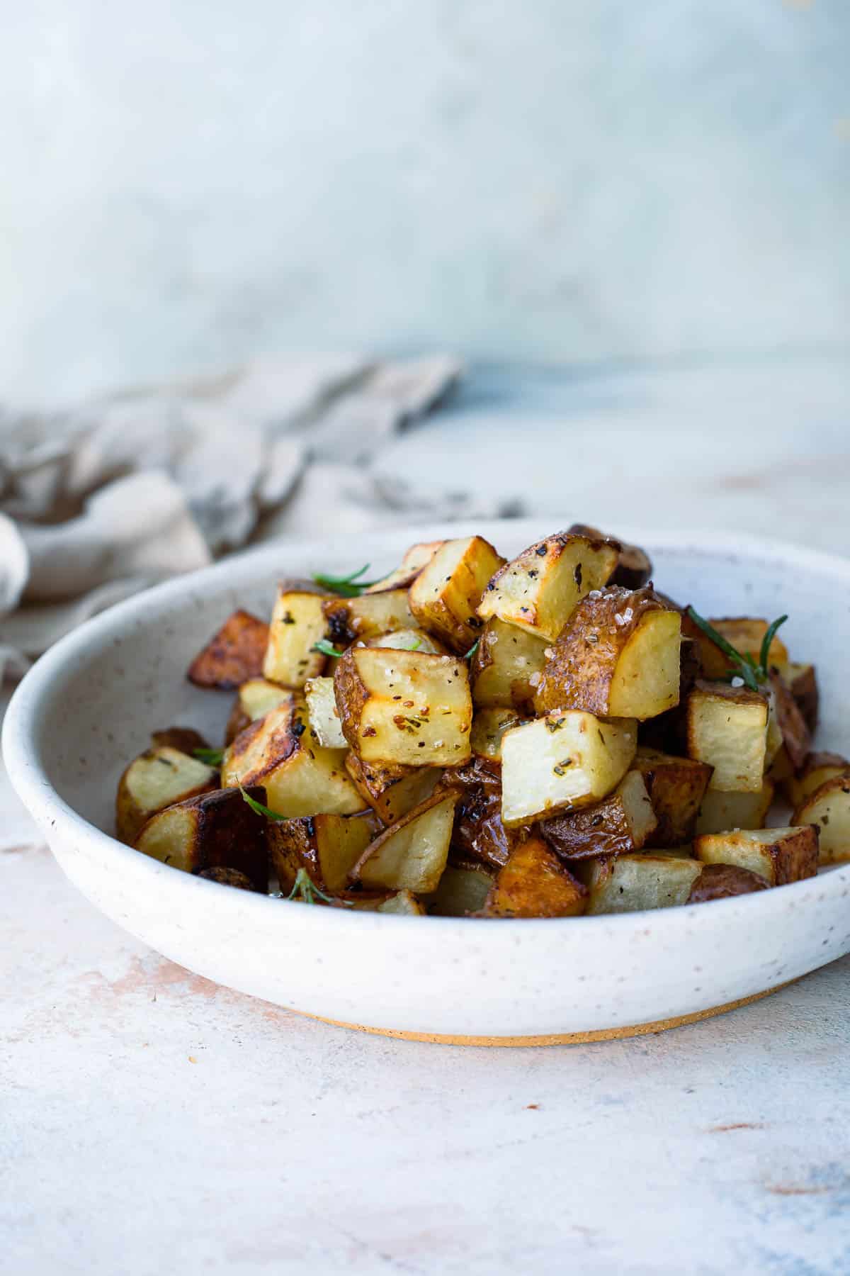 A bowl with oven roasted potato cubes.