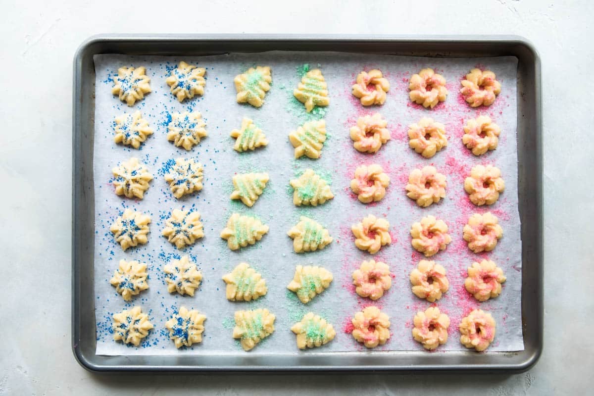 Spritz cookies on a baking sheet before being baked.