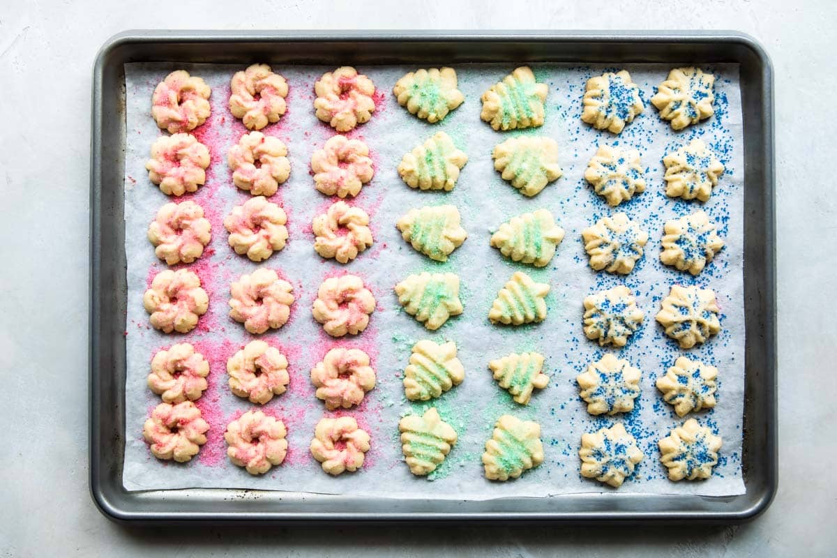 Spritz cookies on a baking sheet after being baked.