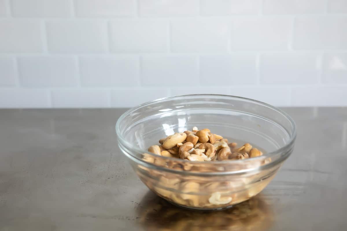A clear bowl with cashews.
