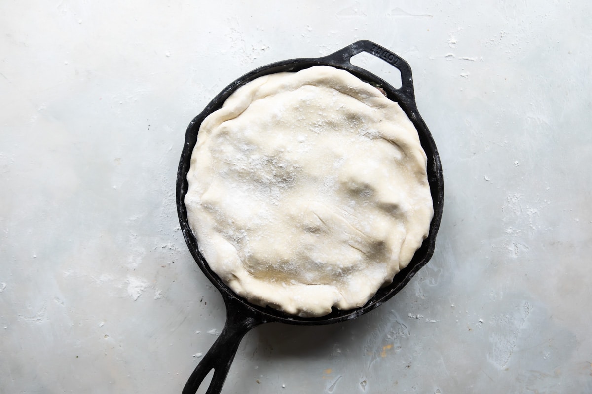 A vegetable pot pie in a cast iron skillet before being baked.