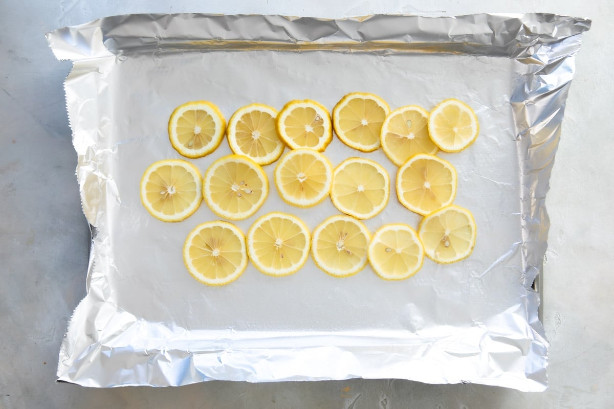 Lemon slices on foil (prep for baked salmon) on a baking sheet.