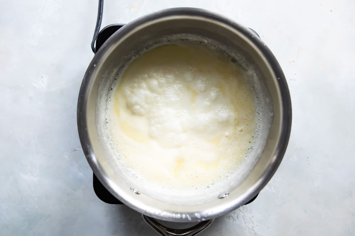 Butter, corn syrup, and heavy cream cooking in a metal pot.