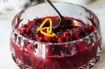 Cranberry sauce in a clear glass decorative bowl.
