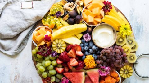 A platter of fresh fruit with fruit dip.