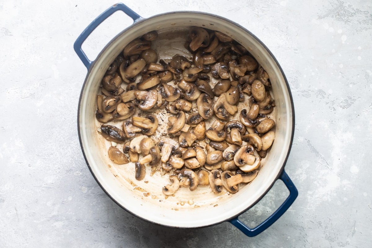 Mushrooms browning in a saucepan.