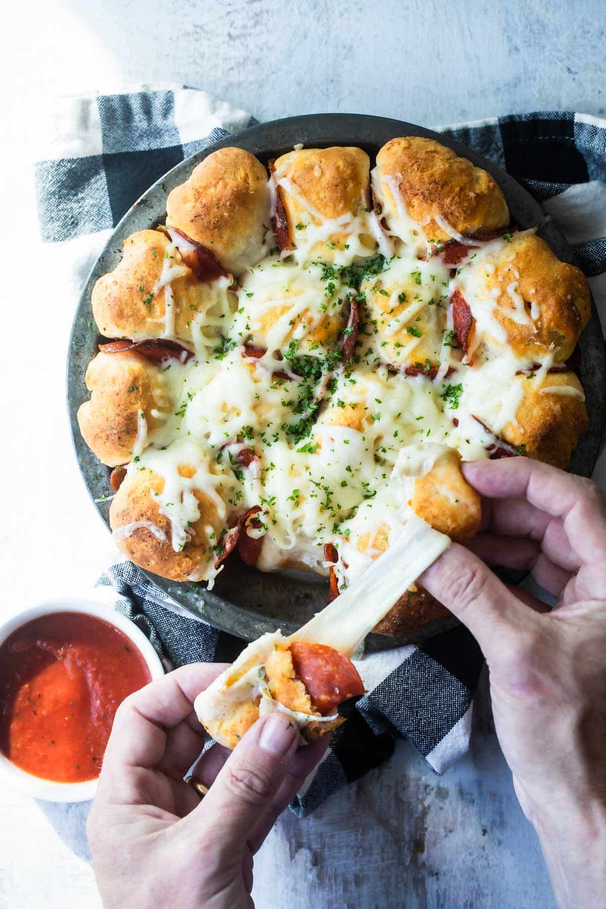 Pepperoni pizza bites being pulled apart.