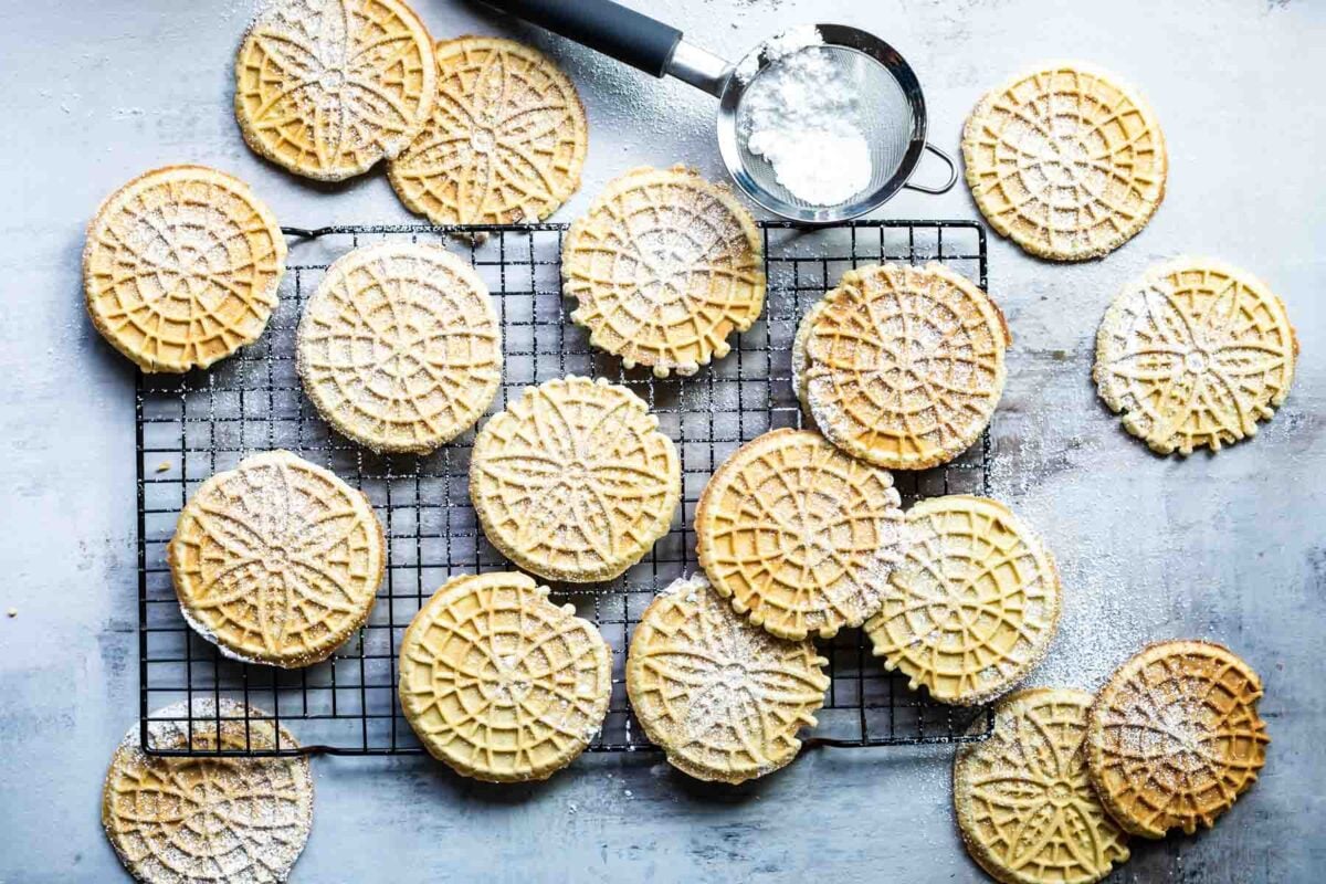 Pizzelle cookies cooling on a baking rack.