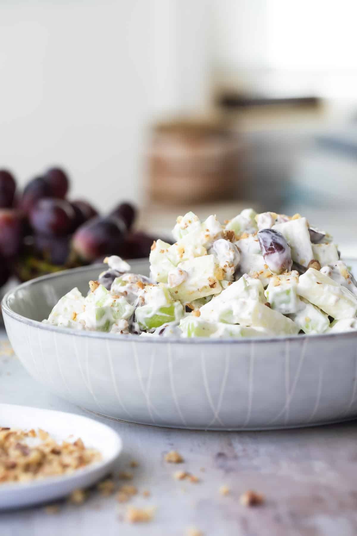 A white, textured serving bowl with waldorf salad in it.