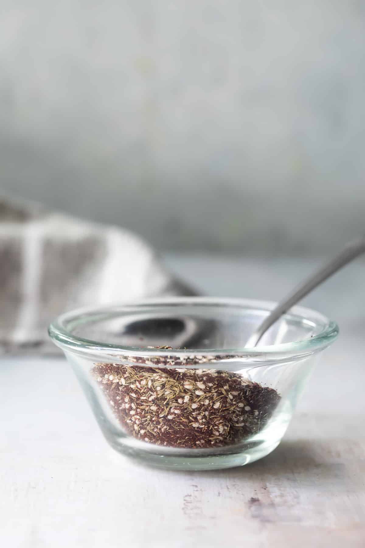 Za'atar seasoning in a clear glass bowl.