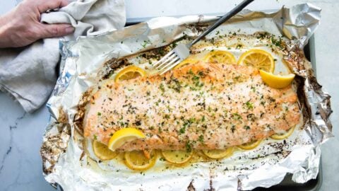 Baked salmon on a foil lined baking sheet after being baked,