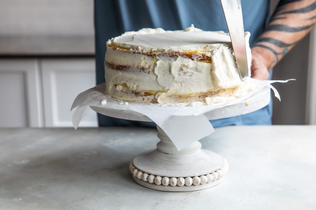 Frosting the sides of a Danish layer cake with vanilla buttercream.