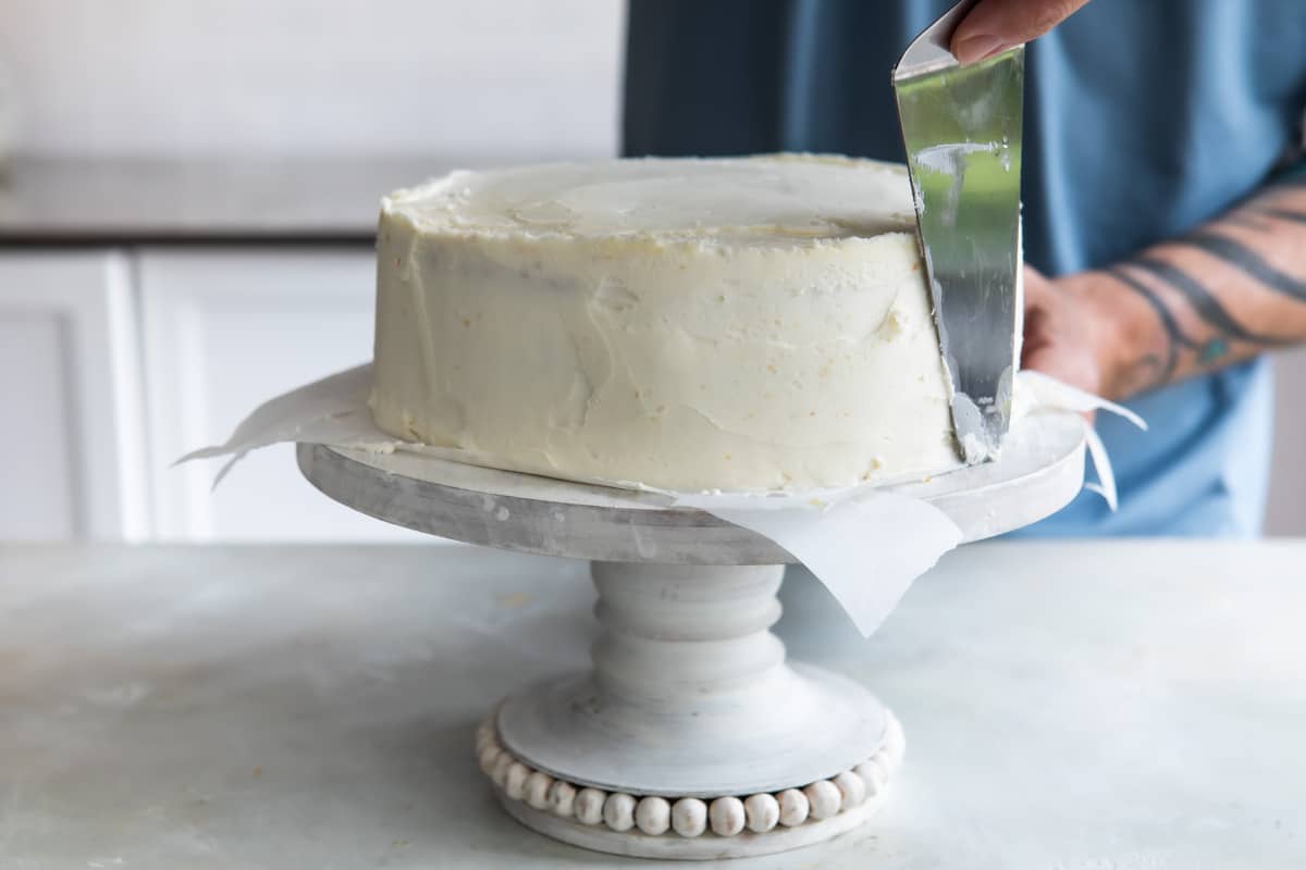 Smoothing the edges of a Danish layer cake with vanilla buttercream.