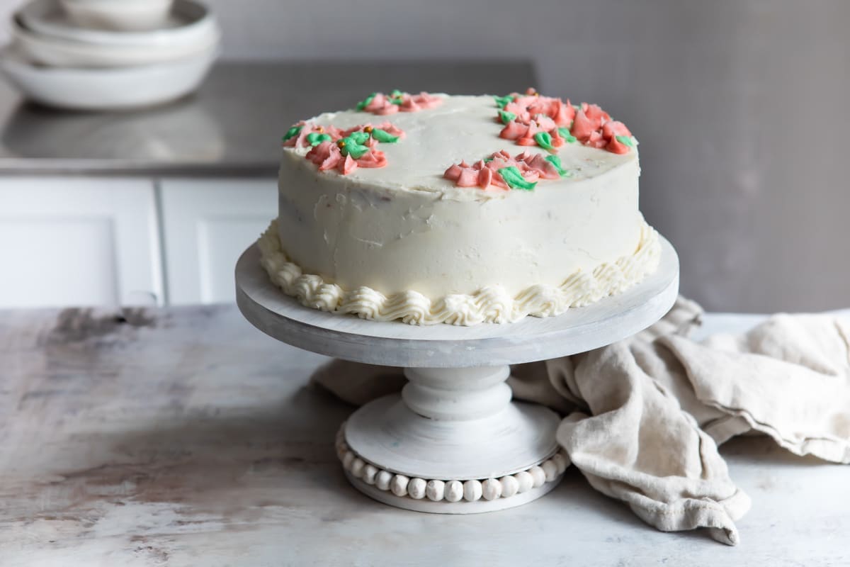 A fully frosted and decorated Danish layer cake on a cake stand.