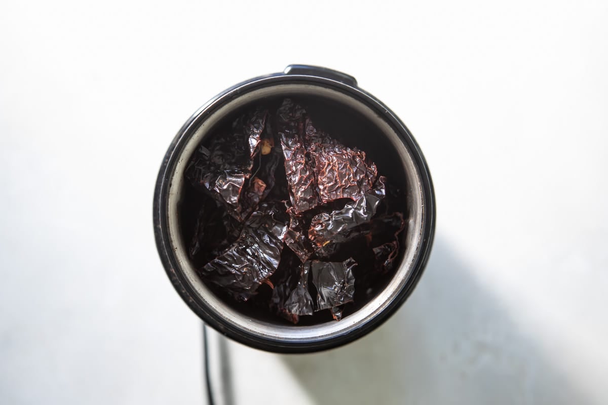 Dried ancho chiles in a spice grinder before grinding.
