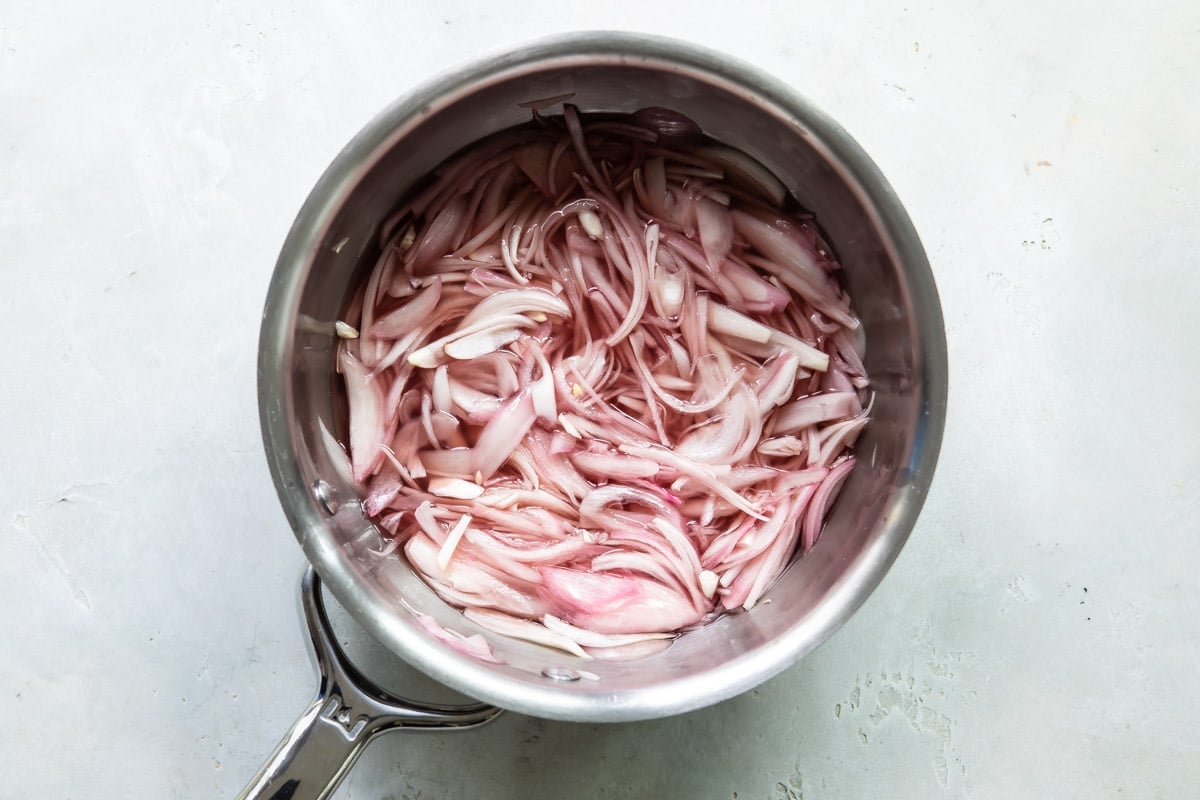 A saucepan full of sliced shallots after pickling.