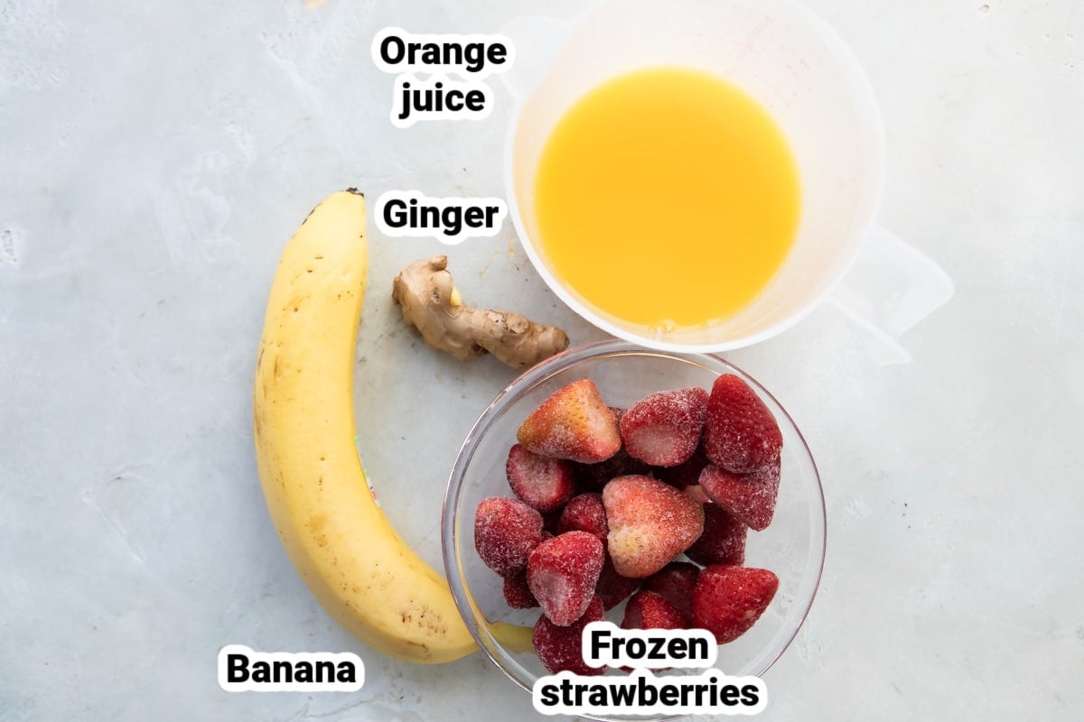 Labeled ingredients for a strawberry citrus ginger smoothie.