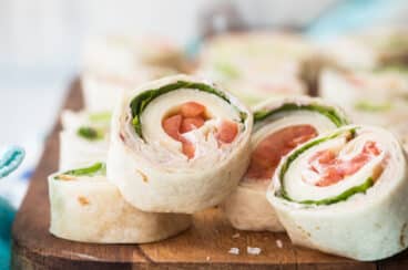 Slices of turkey roll ups on a wooden board.