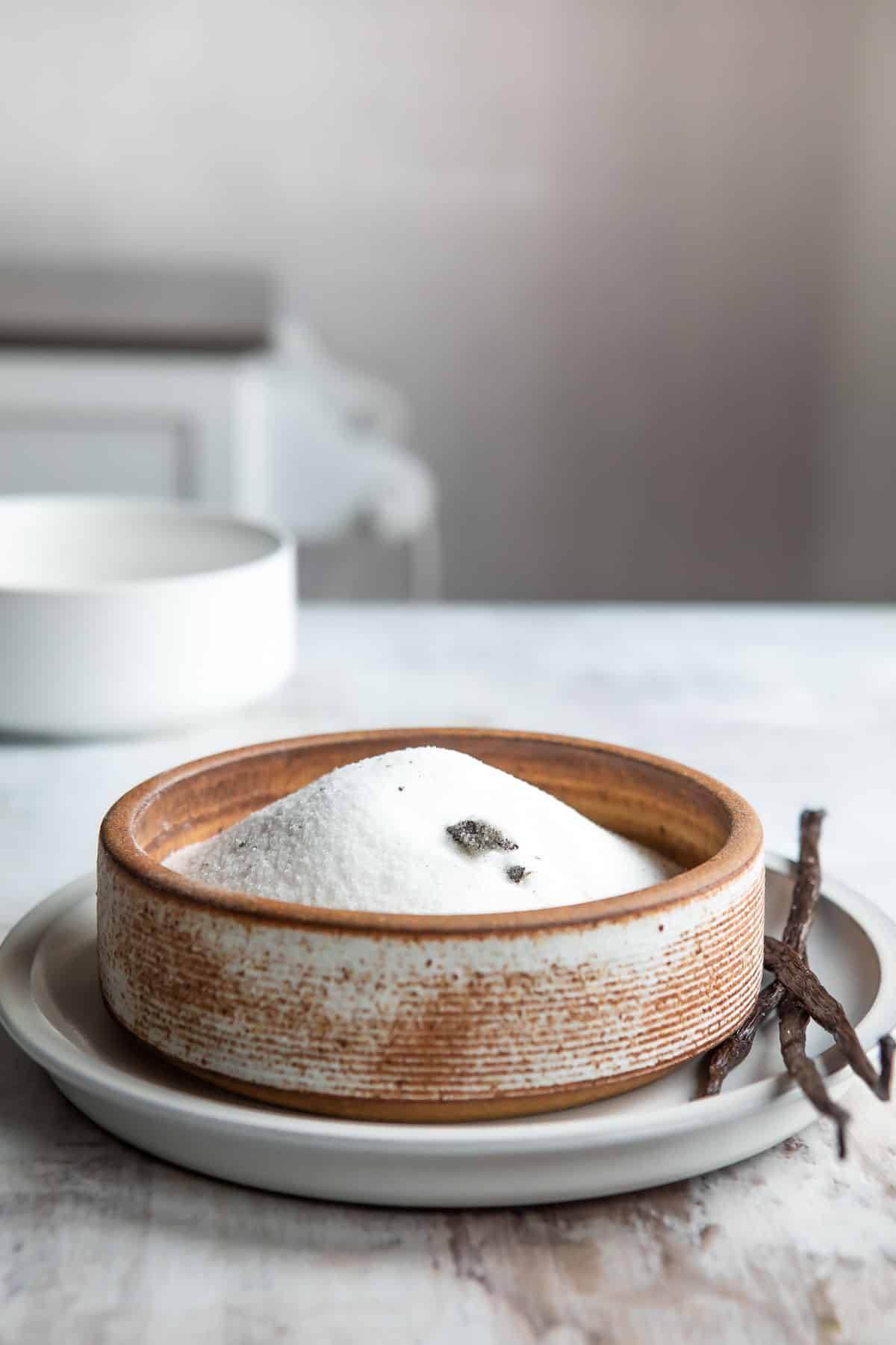 Vanilla sugar in a brown bowl.