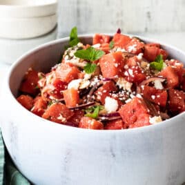 Watermelon in a white serving bowl.