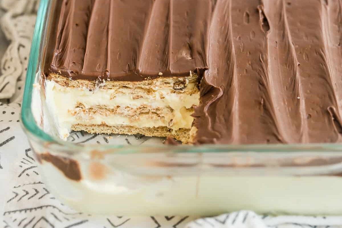 A pan of Chocolate Eclair Cake with a slice missing so you can see inside.