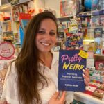 A photo of Marissa Miller holding her book, "Pretty Weird: Overcoming Impostor Syndrome."