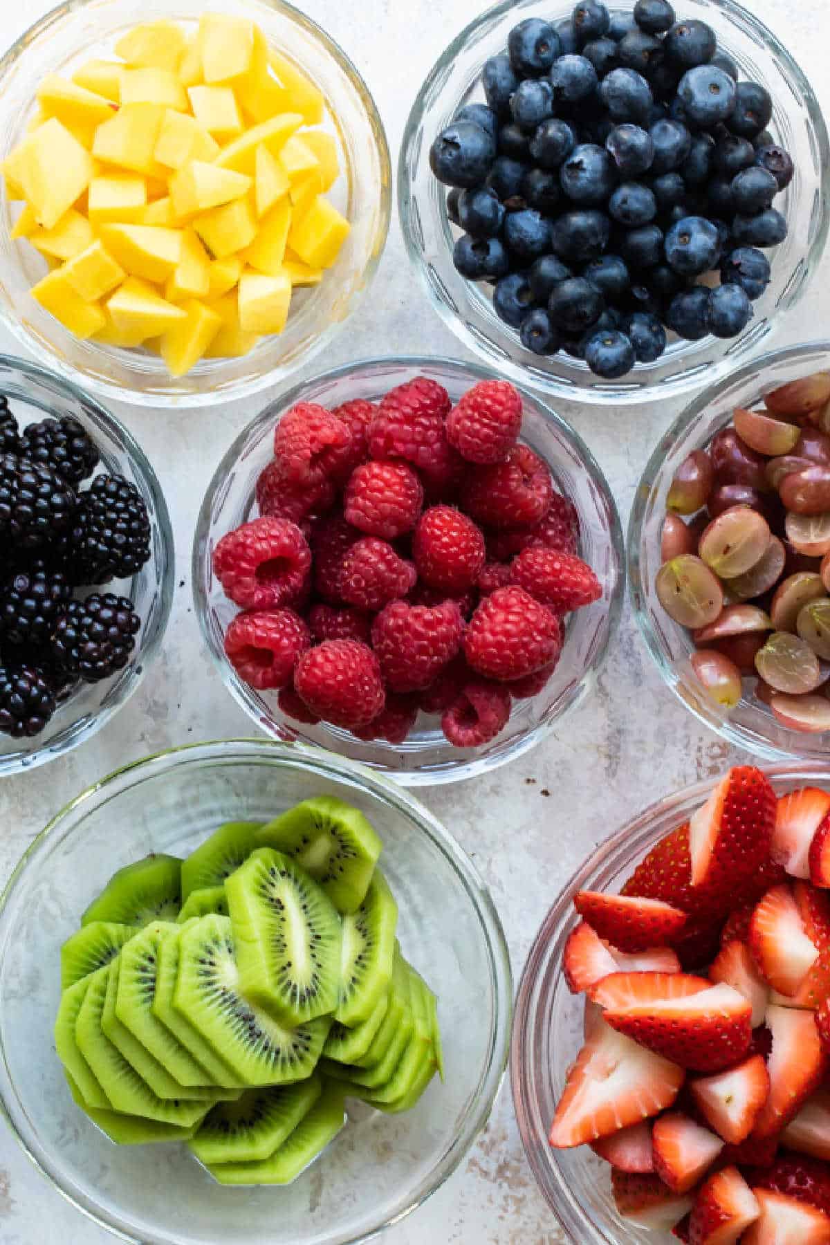 Bowls of fresh fruit on a white background.