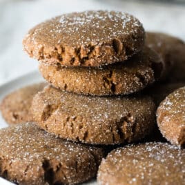 A stack of molasses cookies on a white plate.