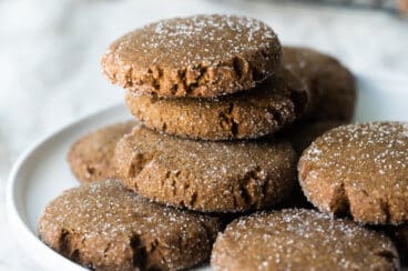 A stack of molasses cookies on a white plate.