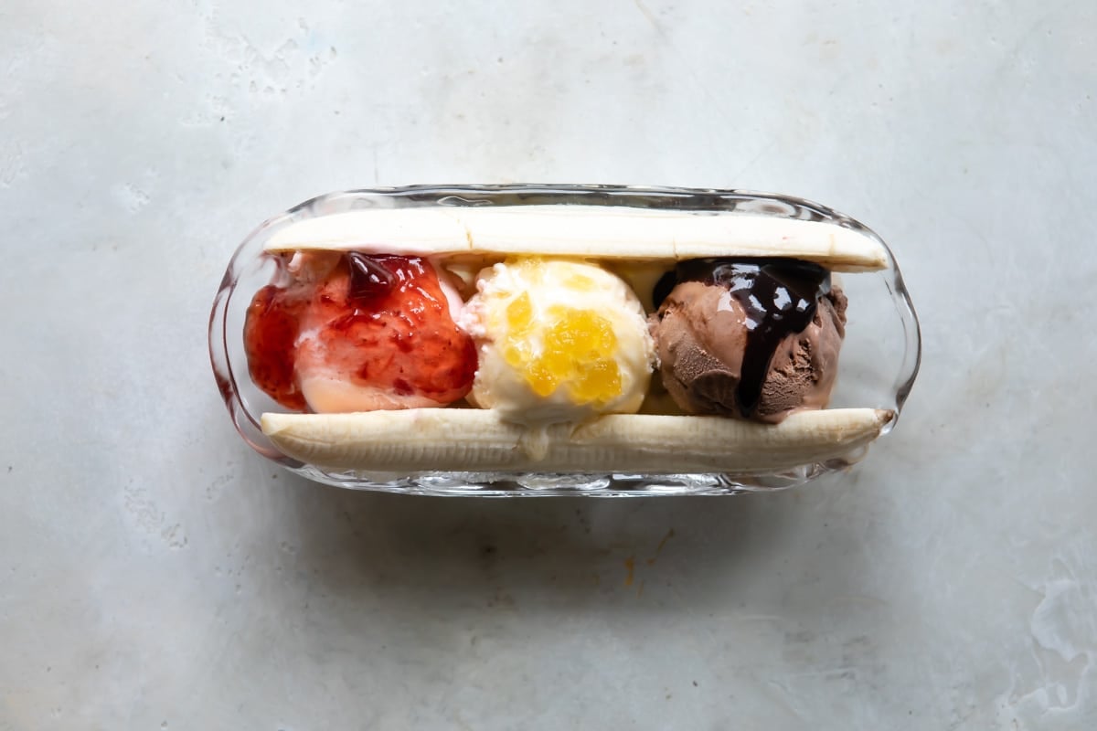 A split banana with ice cream and toppings in the middle.
