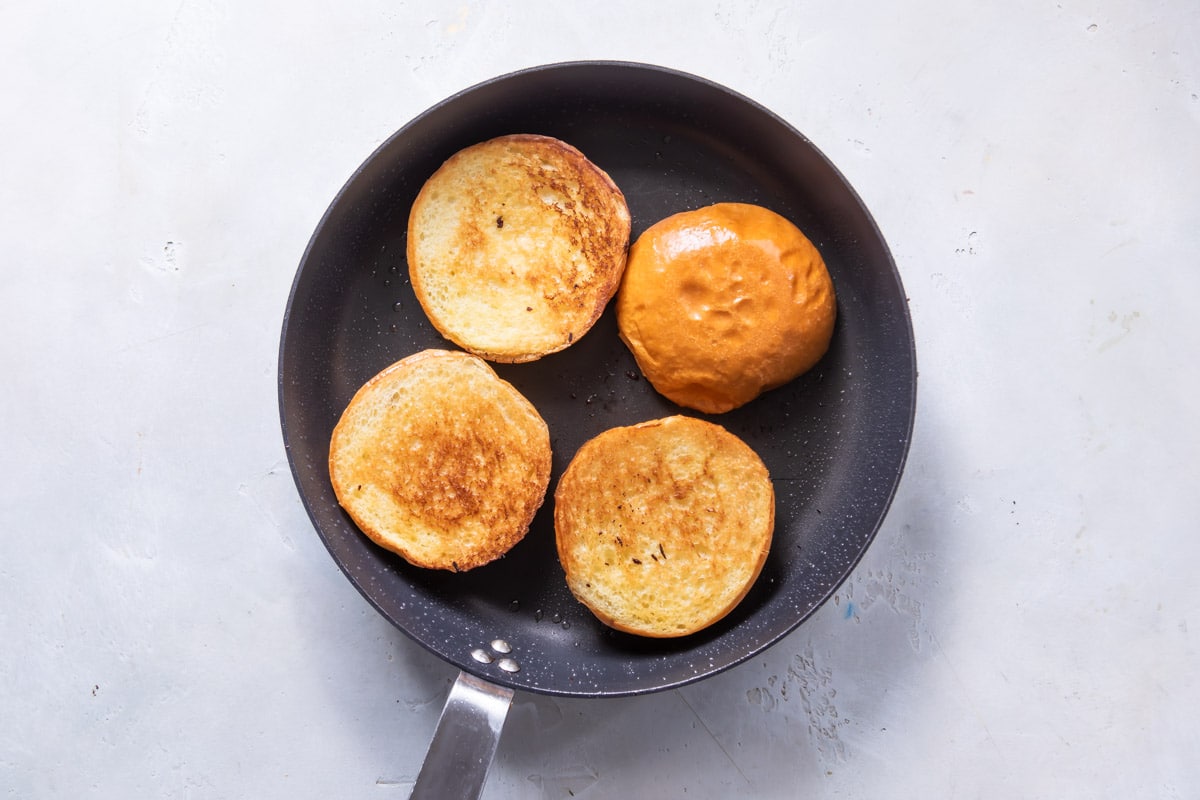 Toasting buns in a skillet.