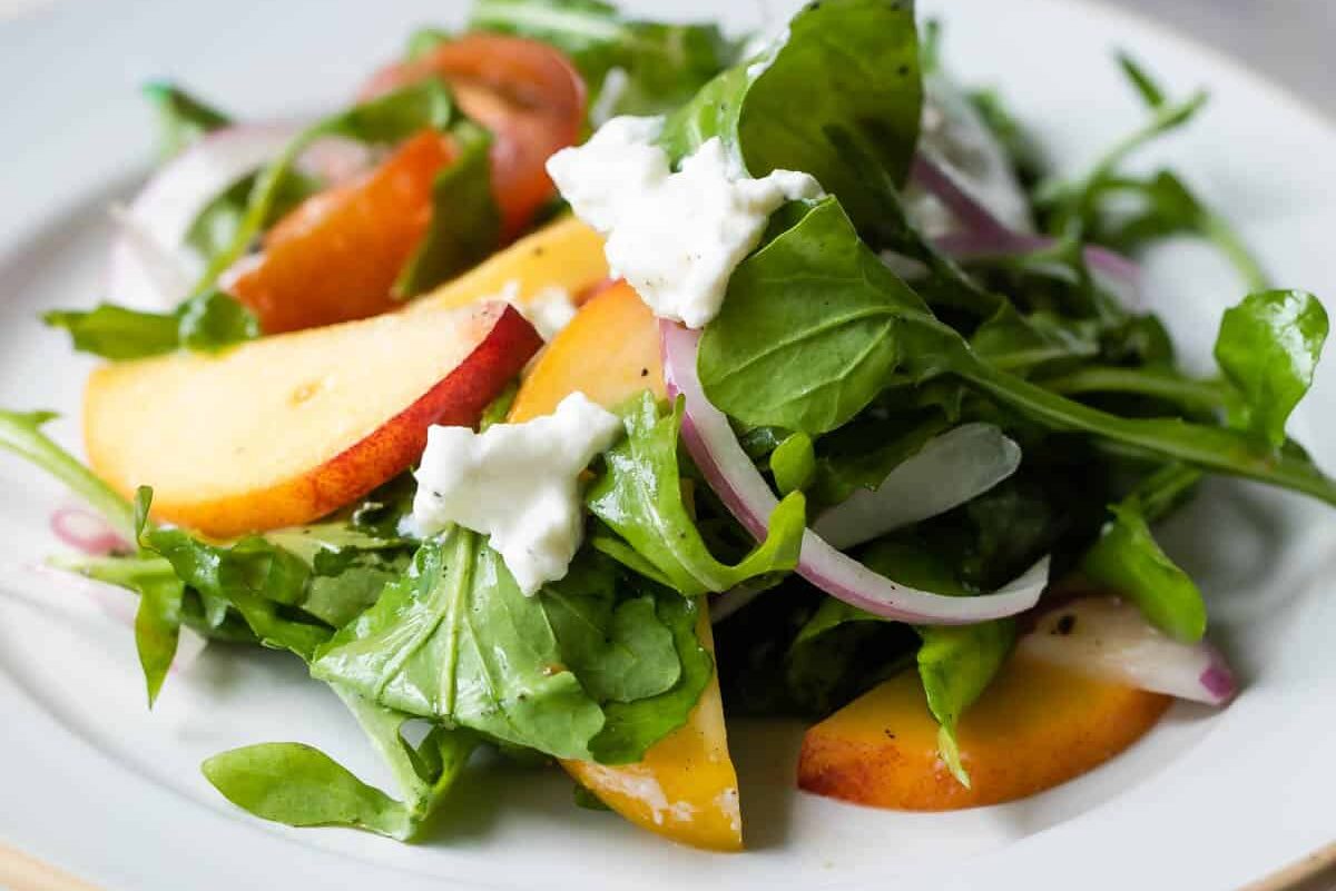 A plate of burrata salad with peaches.
