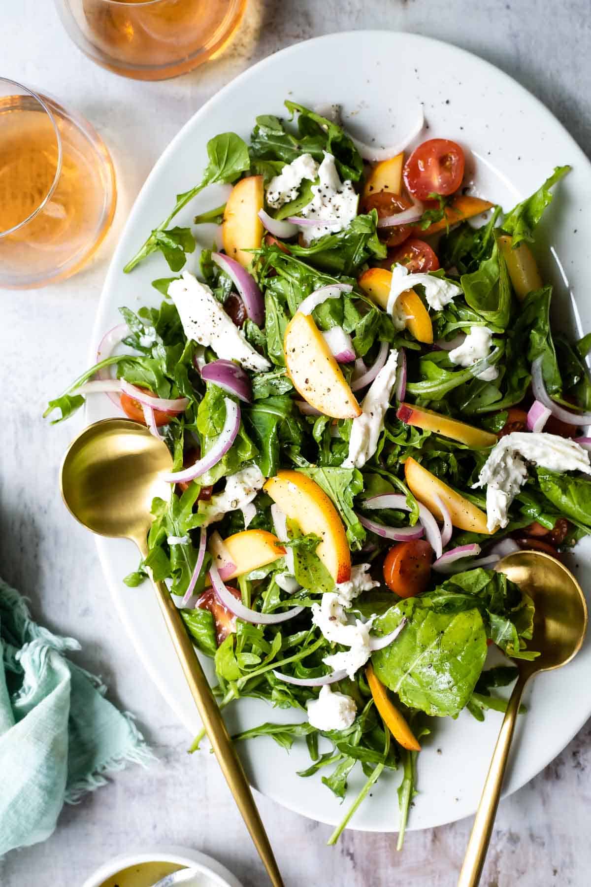 A platter of burrata salad with peaches.
