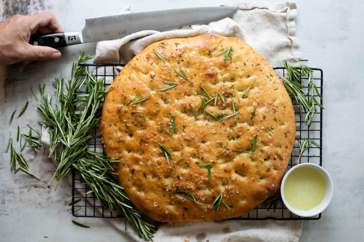 A full, unsliced loaf of focaccia bread.