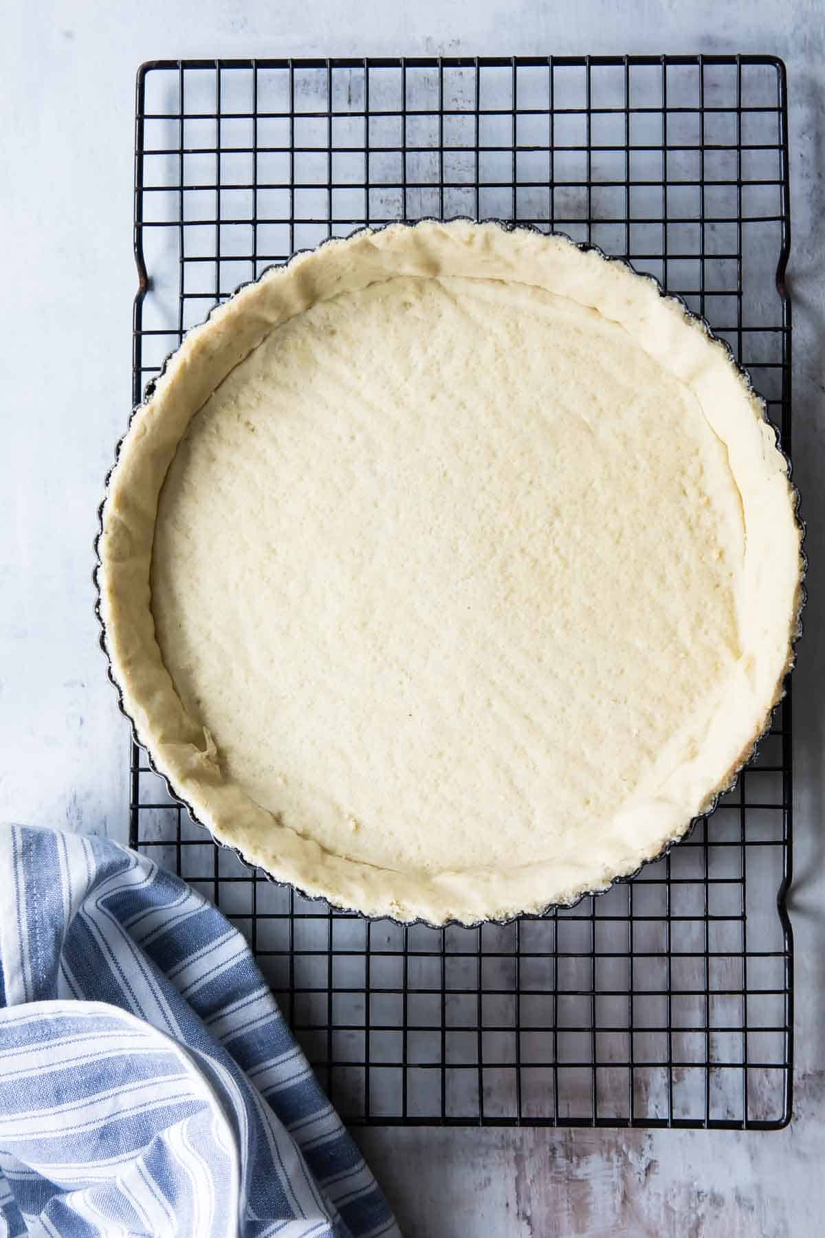 A tart crust on a wire cooling rack.