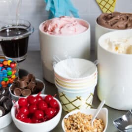 Ice cream and toppings on a countertop for an ice cream sundae bar.