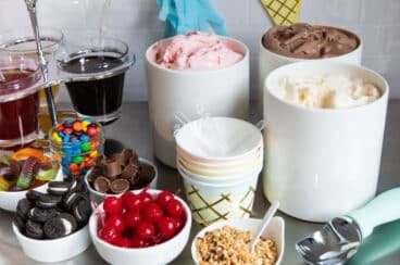 Ice cream and toppings on a countertop for an ice cream sundae bar.