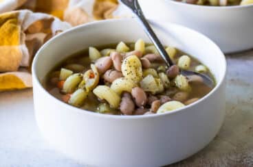 Slow cooker pasta and bean soup in a white bowl.