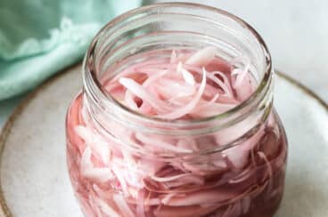 A clear jar of pickled shallots.